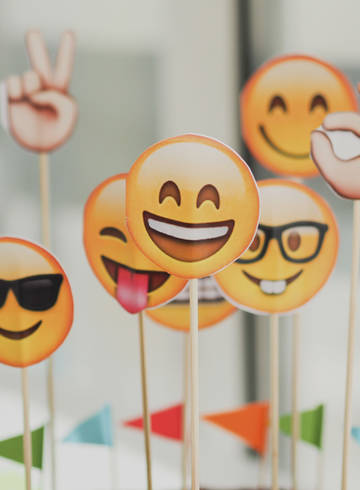 Emojis aus Papier, die auf einem Kuchen stecken